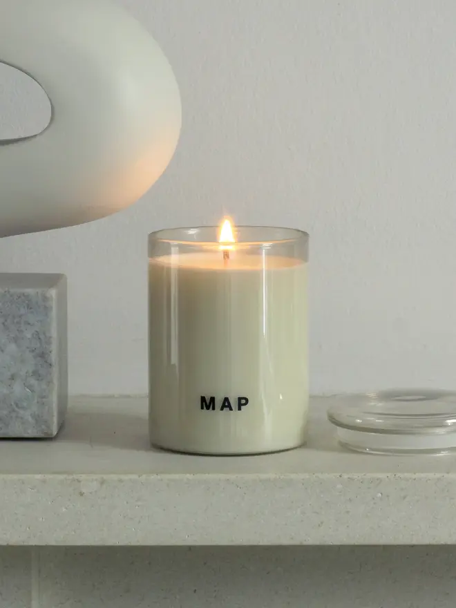 sunbeam clary sage and bergamot soy candle. candle photographed on shelf. 