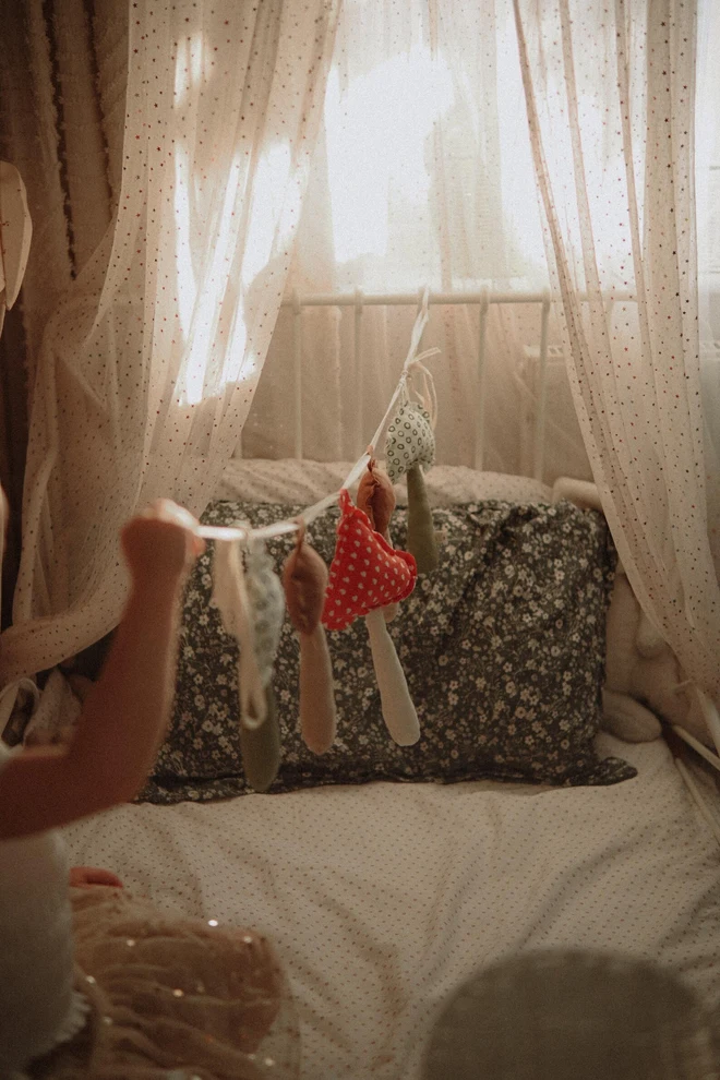 Mushroom Garland Decoration, a child playing with their hanging mushroom bunting in their bedroom.  