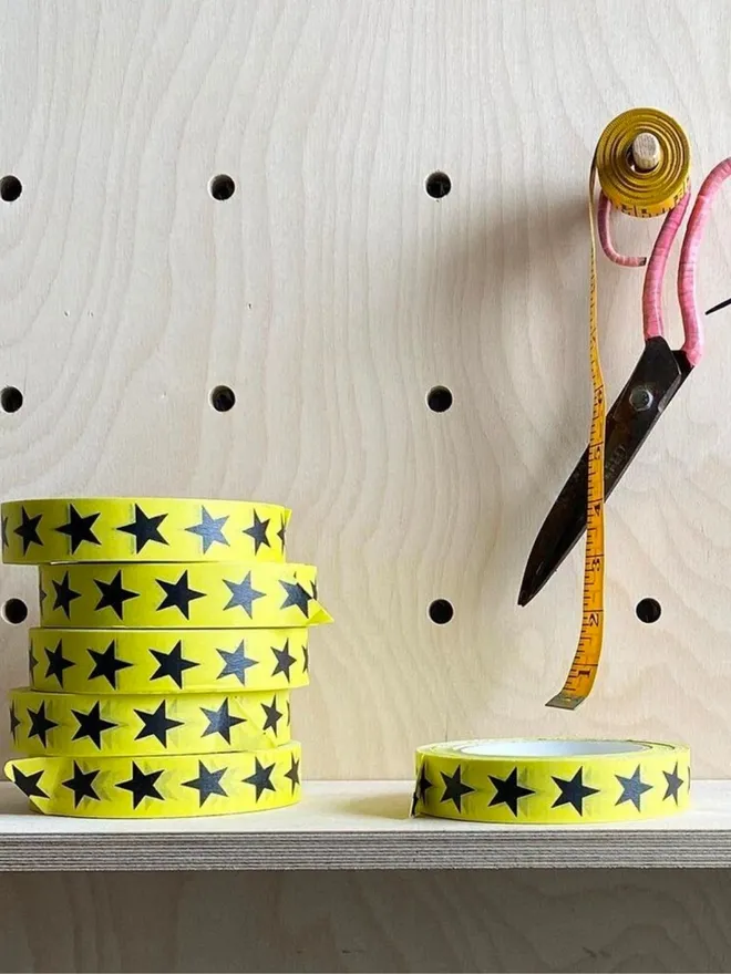 Yellow and black star print adhsive paper tape on a shelf.