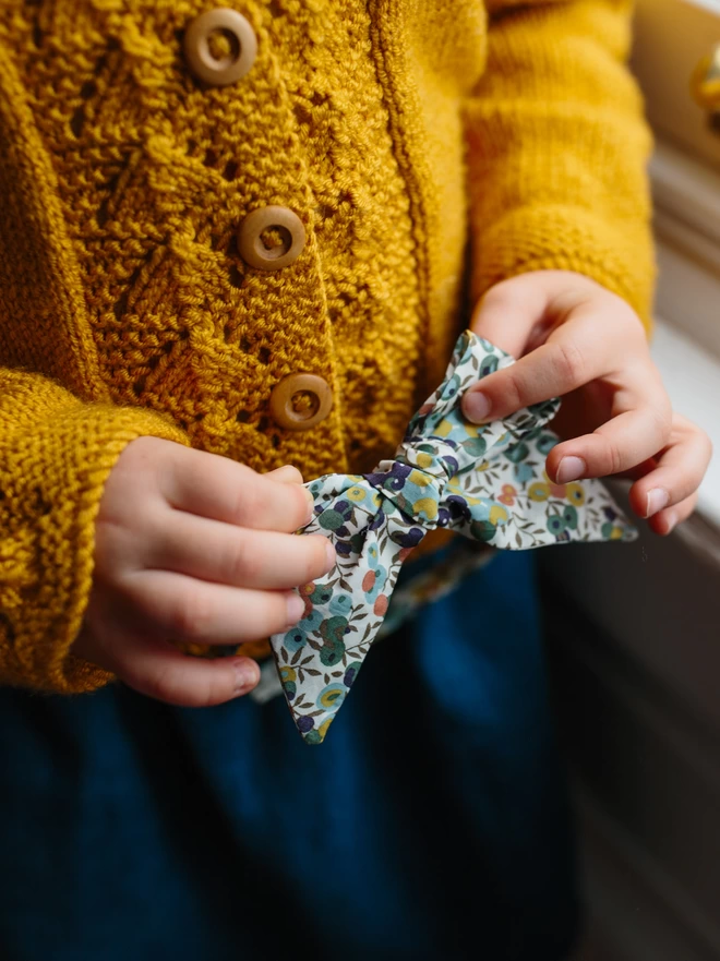 little hands holding a large bow alice band