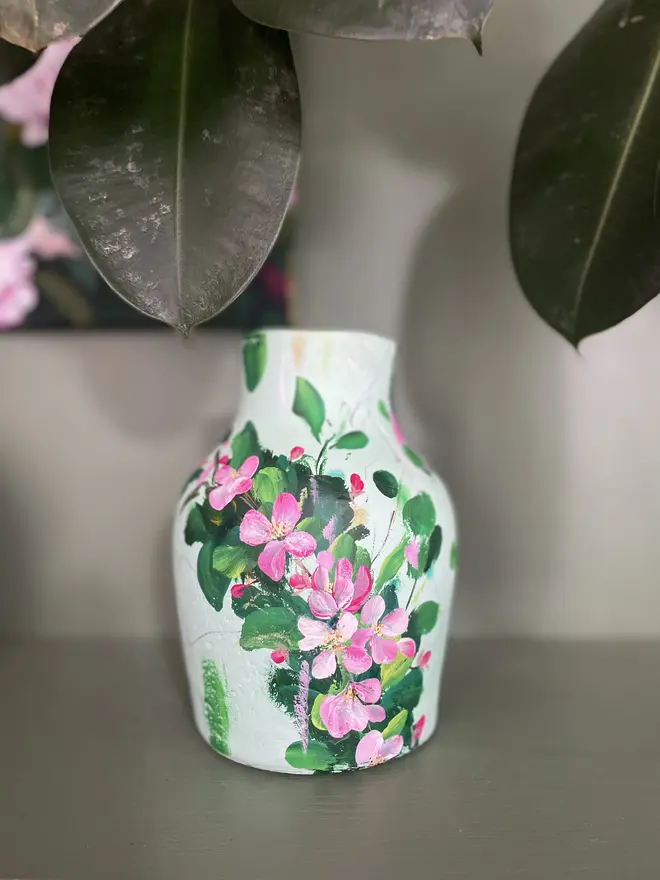 hand painted terracotta floral dried flowers vase pale green background with pink and white apple blossom flowers.