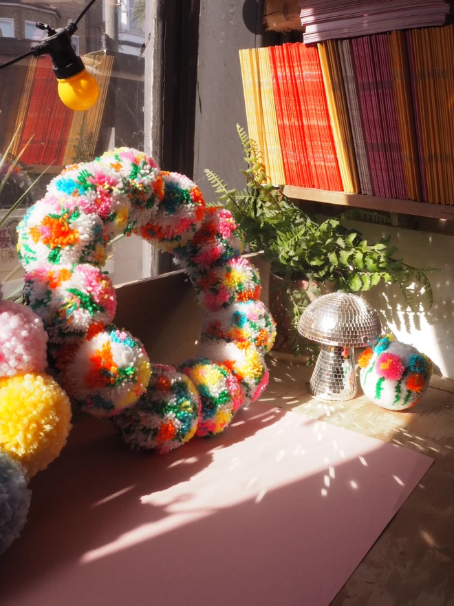 floral meadow pom pom wreath in the window