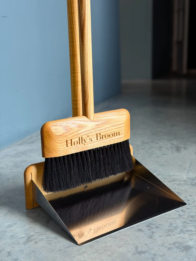 Personalised broom resting on its stainless-steel dustpan