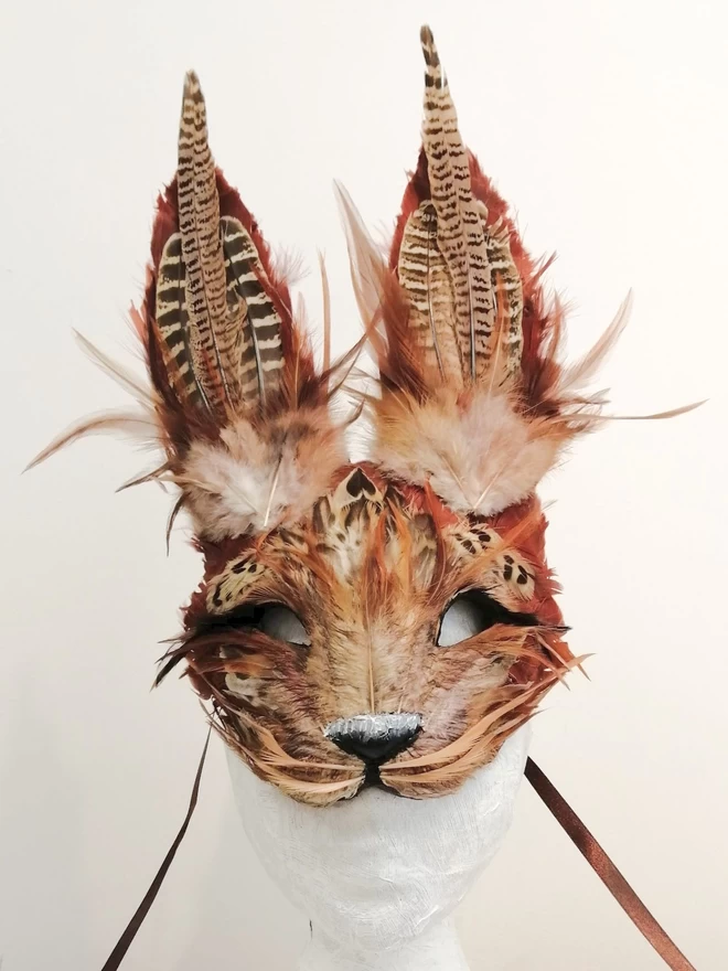 A luxury brown hare masquerade mask on a display mannequin head