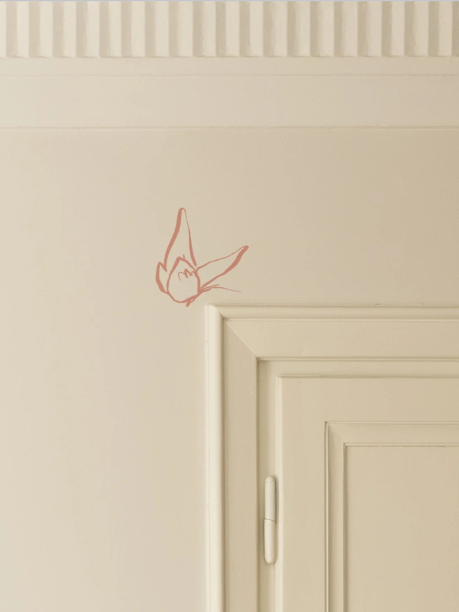 pink butterfly wall sticker sitting above a door frame