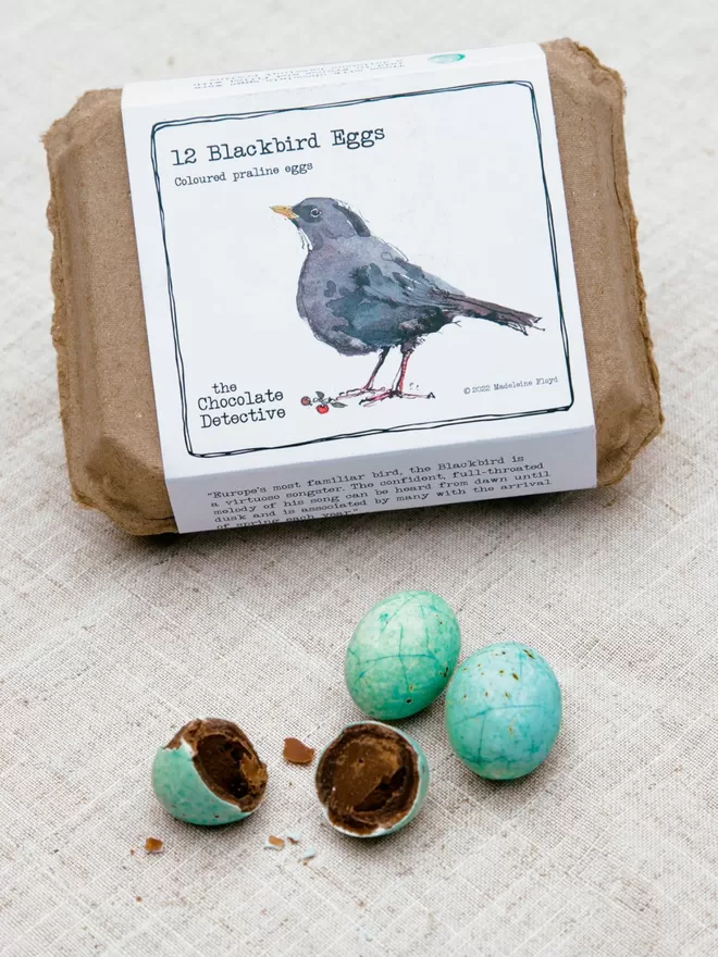 Blackbird eggs with box seen on a linen tablecloth.