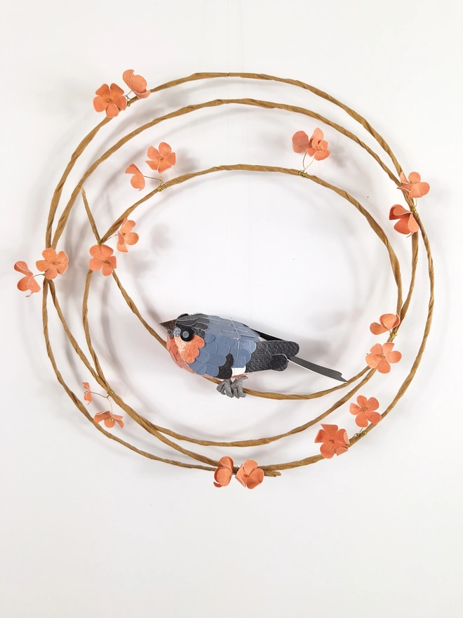 handmade paper art of a bullfinch bird sculpture