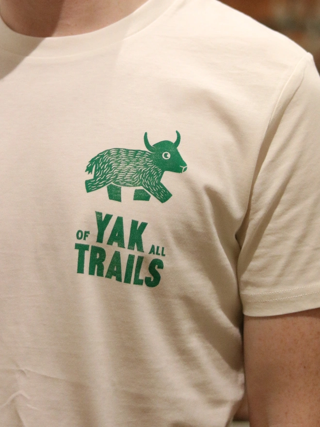 Man wearing a t-shirt with a Yak linocut image printed on the white tshirt.