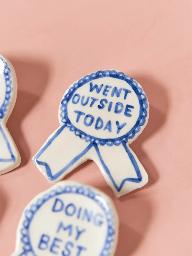 Blue Handmade Ceramic Award, a group of blue and white ceramic award badges sitting on a ink surface. 