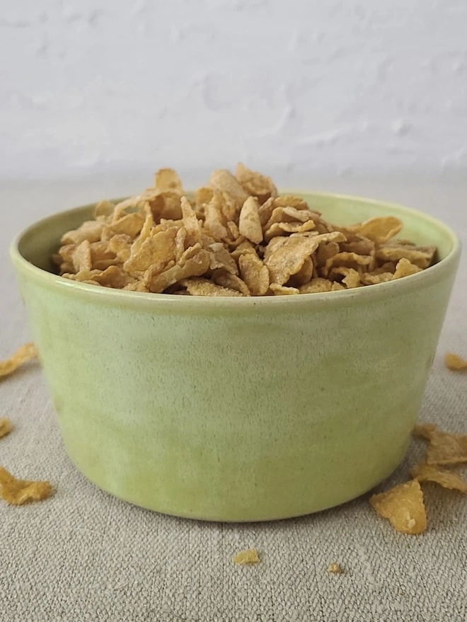 Classic Ceramic Breakfast Bowl, a breakfast bowl sitting on a grey carpet against a plain backdrop. It is accompanied by some cereal. 