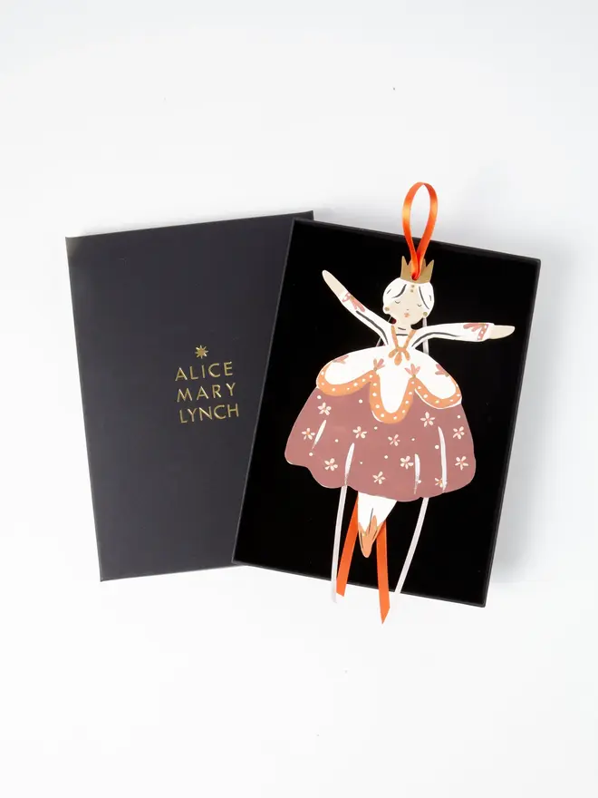 Belle Tree Dancer. wooden hanging ballerina decoration in an open black gift box embossed "alice mary lynch" in gold, with terracotta floral skirt, cream bodice and orange and white ribbon ties