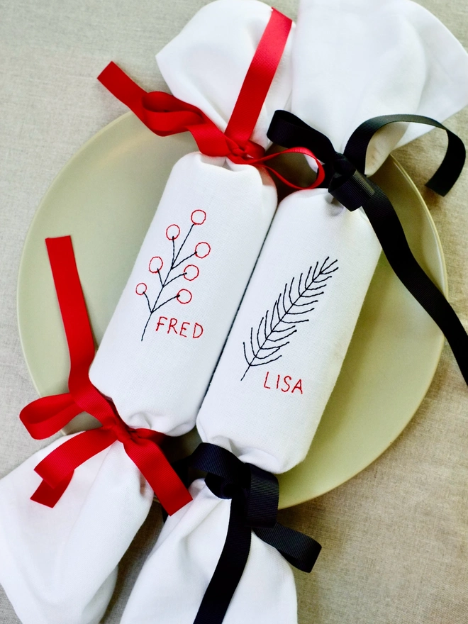 Personalised name fabric Christmas crackers with berry and fir designs and red and black ribbons