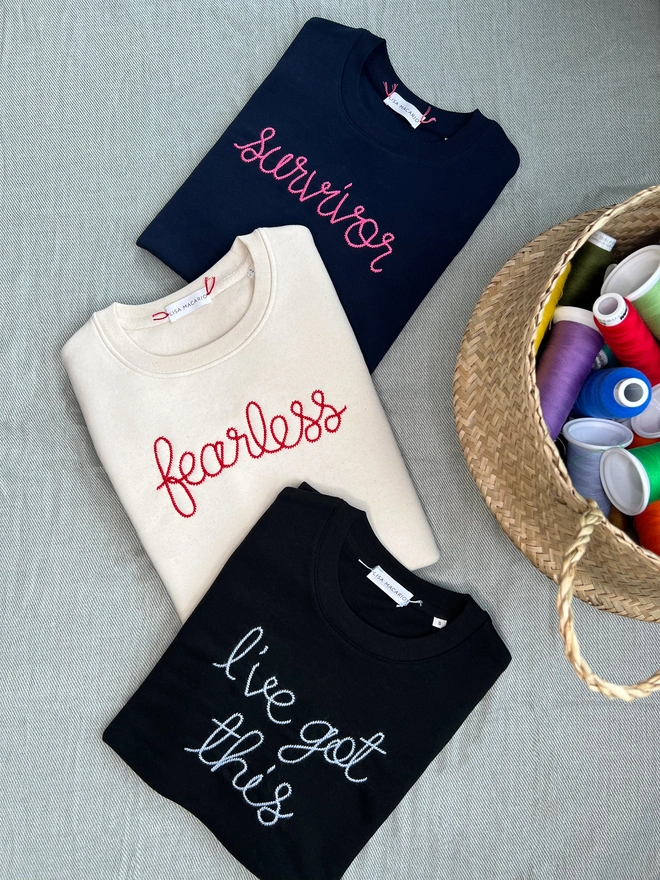 Three embroidered sweatshirts with slogans: Survivor, Fearless, and I’ve Got This