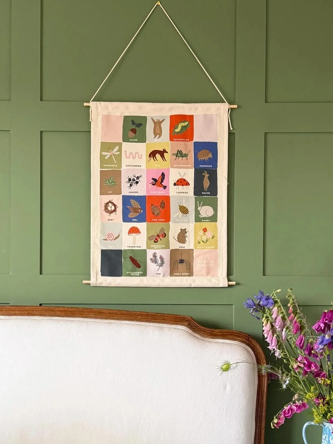 Rainbow Woodland Alphabet Fabric Banner hanging above bed on green wall