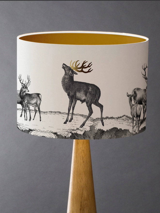 lampshade featuring a majestic herd of Highland stags with striking gold antler detailing, inspired by a Scottish wedding and bringing elegant country charm to any interior.