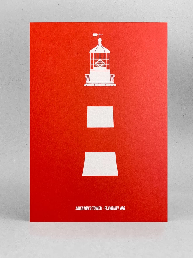 Plymouth lighthouse Smeaton's Tower is screenprinted in white only on a red card, showcasing the stripes and details of the light at the top. It's title is written at the base. The card is stood in a light grey studio with soft shadow.