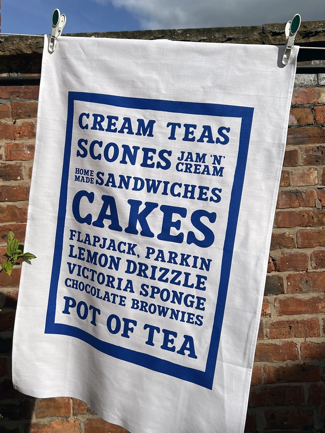 Mr.PS Cakes Tea Towel hanging in the sunshine