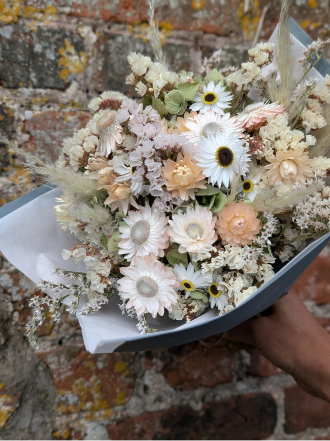 seashell dried flower bouquet. white and neutral coloured dried flower bouquet wrapped in paper.