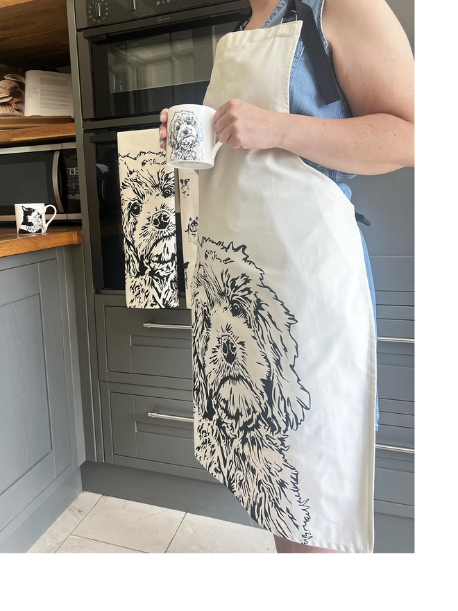 Cockapoo apron being worn with a matching cockapoo mug in model's hand