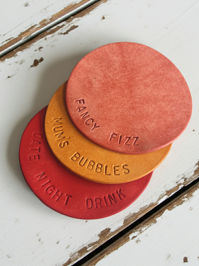 leather coasters in pink, yellow and red
