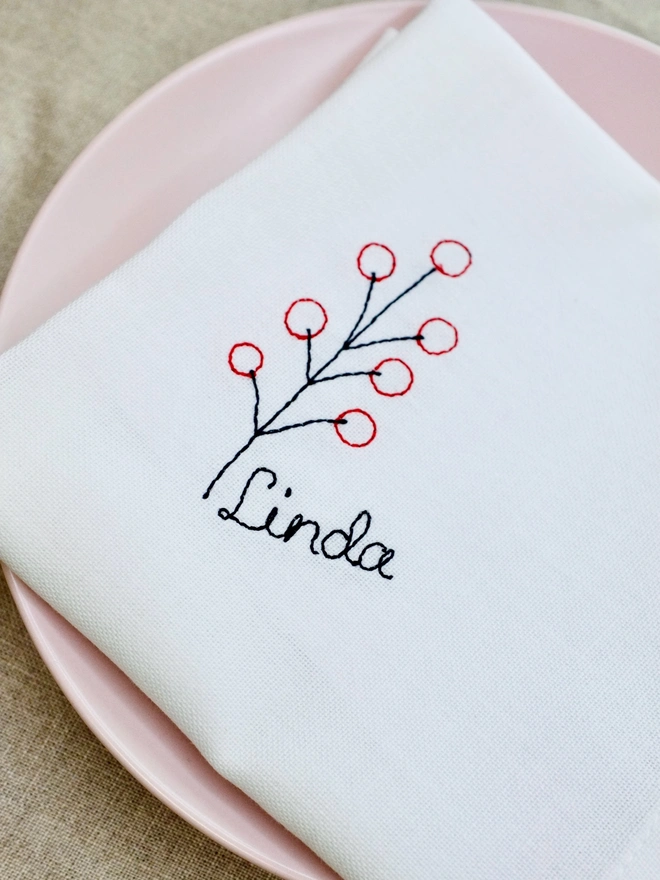 Berry embroidered napkin with custom name in black cursive text, cotton Christmas napkin