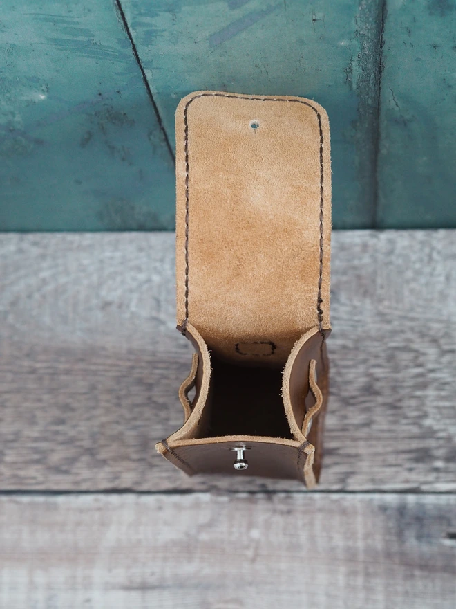 Handmade leather golf ball and tee carry case. The side of the case features a small band of leather rivetted to allow for a single tee to be held securely in place.