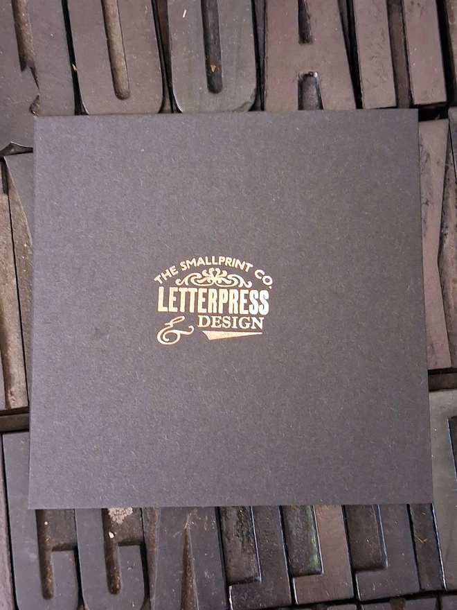 A greetings card printed in gold foil on black card with a picture of a disco ball