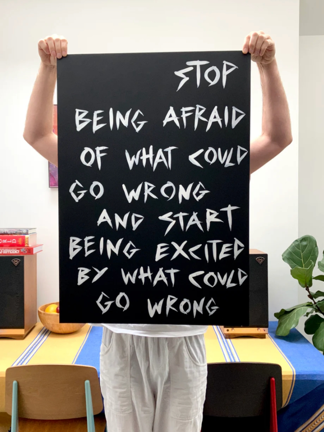 'Stop Being Afraid' painting. White ink on black paper.