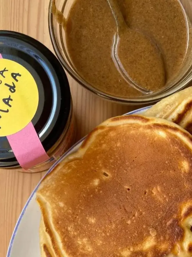 White Sesame Praline Spread, in a bowl next to pancakes. 