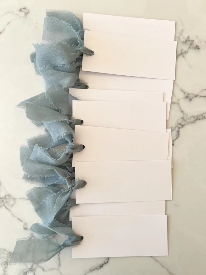 Personalised Calligraphy Wedding White Place Cards, white place cards with dusky blue chiffon ribbon. 