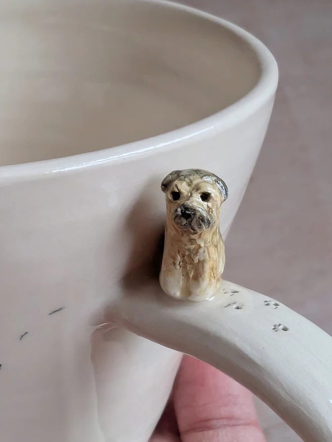 tiny border terrier dog on a white cup with pawprints