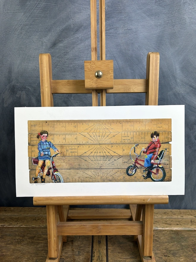 two children sitting on bikes painted onto vintage school rulers