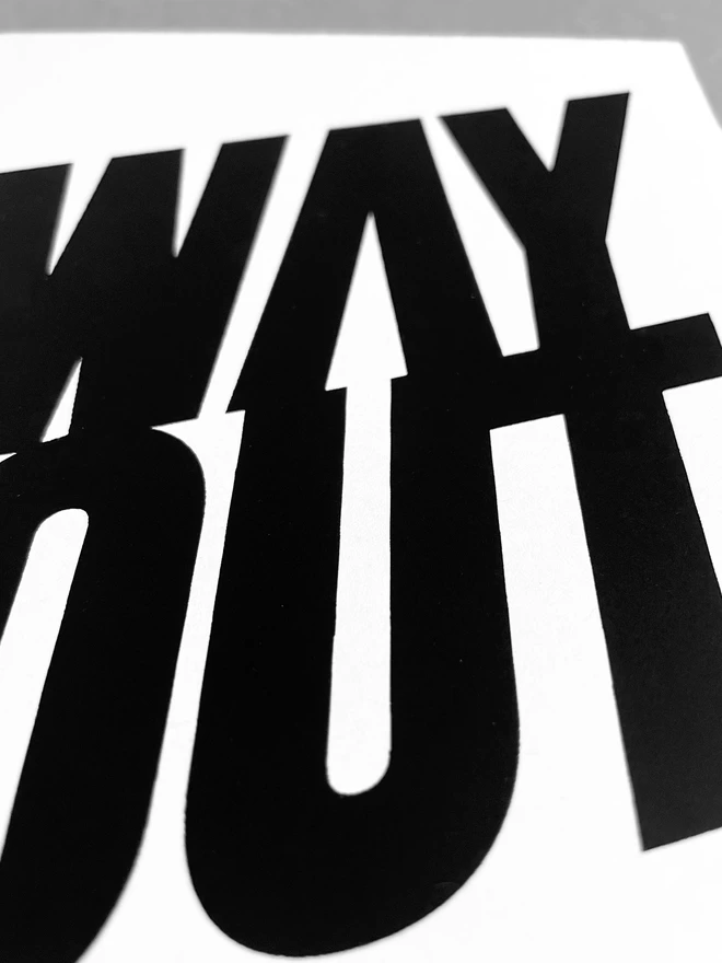 Close up of WAY OUT screenprinted in black ink, showing the arrow hidden in the negative space of the words, pointing upwards.