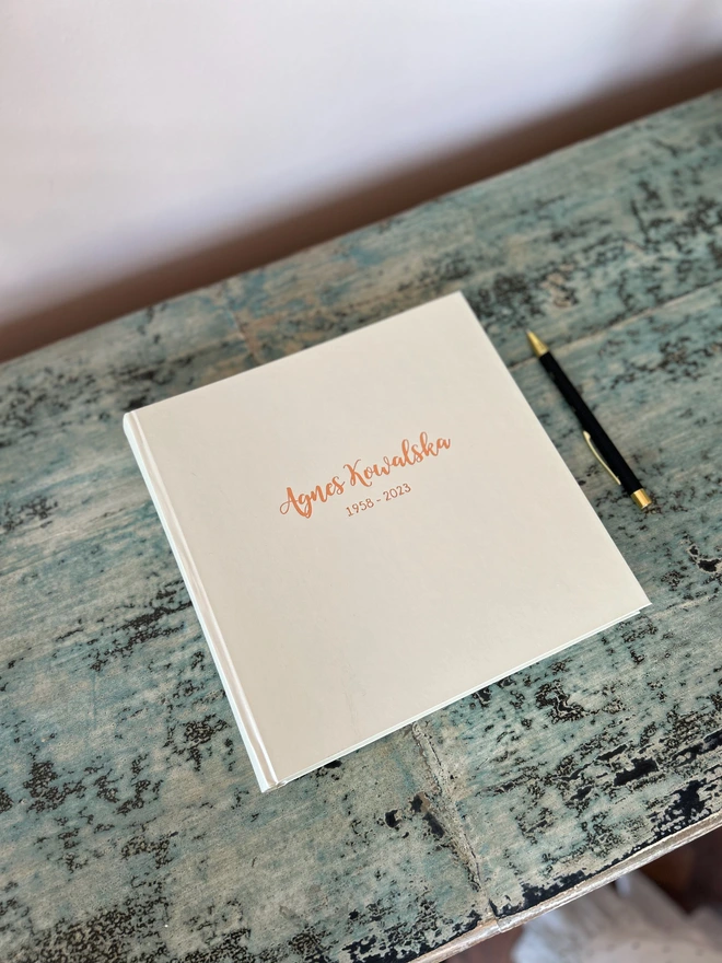 Large Personalised Condolence Book Bound And Embossed resting on a table.