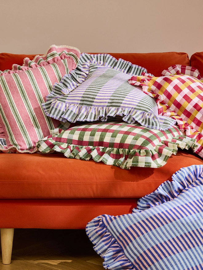 Parma Violet Cushion. Multiple Cushions. Parma Violet is on top in the middle.