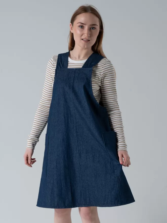 Trapeze line denim pinafore dress. Knee length with 2 large patch pockets.