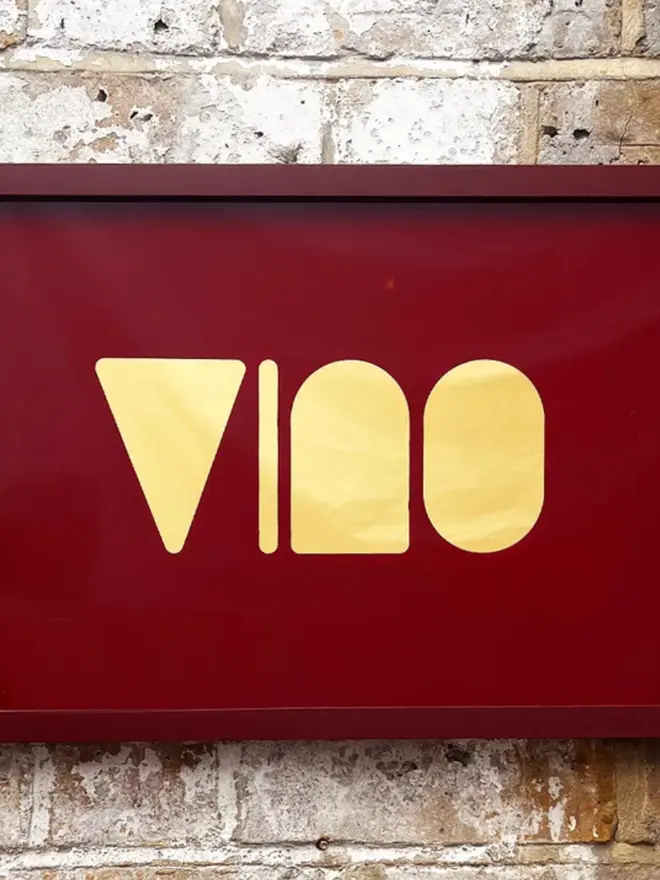 'Vino' Wine Serie Gold Leaf Glass Artwork, hanging in an exposed brick wall. 
