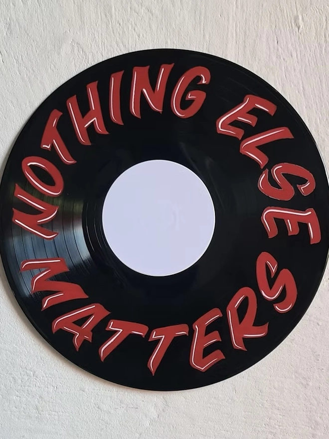 'Nothing Else Matters' Vinyl Artwork, a colourful vinyl sitting on a stone surface. 