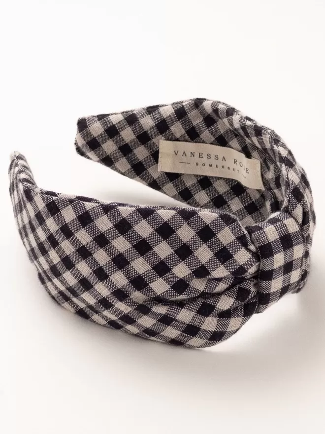 Vanessa Rose Ines Hairband in Washed Black Gingham seen on the side with a label.