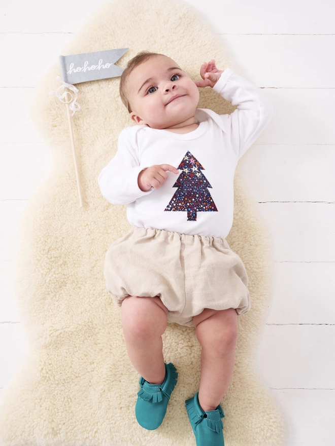 baby wearing a starry Liberty print Christmas tree white bodysuit 
