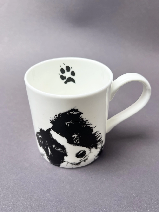 Black and white border collie mug showing the cute collie paw on the inside and collie face on the front