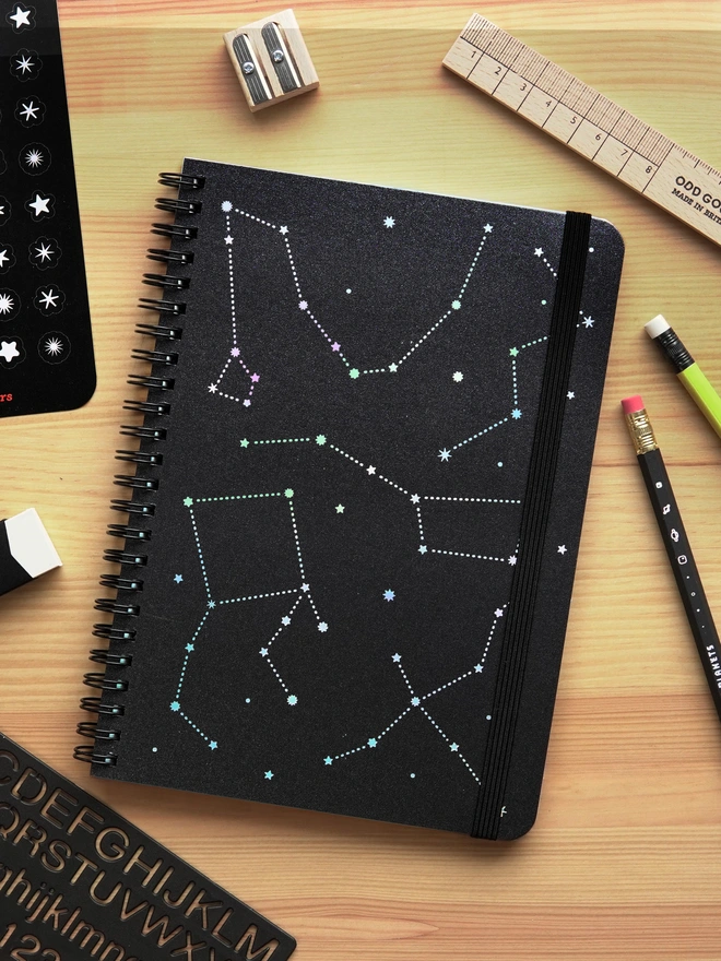 Odd Goose Stargazer foil printed star wire bound notebook top down angle with stationery