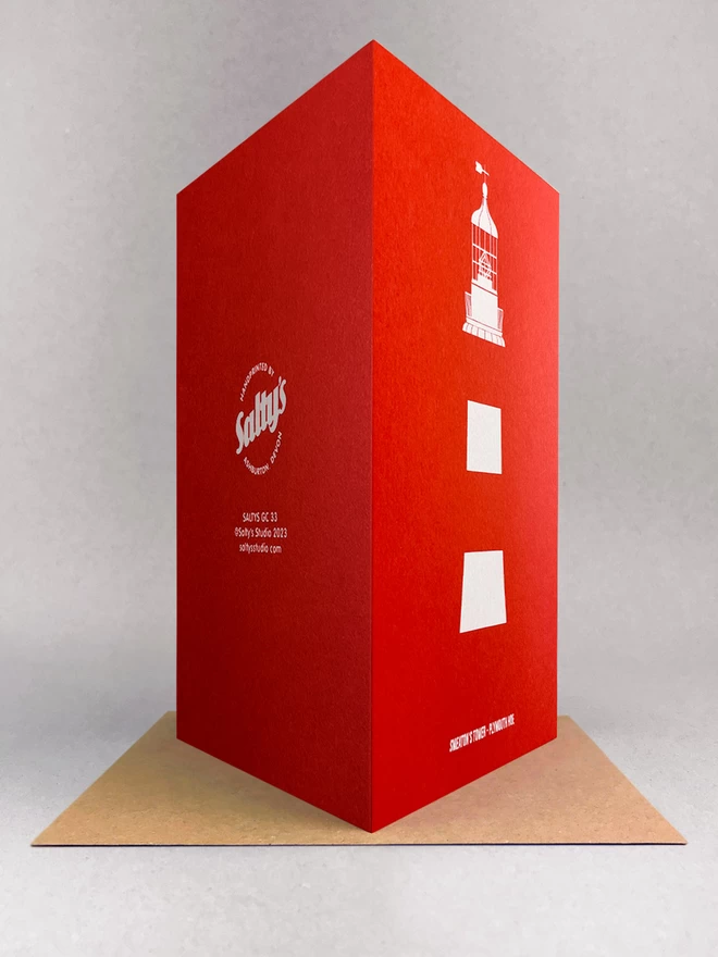 rear view of Plymouth lighthouse Smeaton's Tower, screenprinted in white only on a red card, showcasing the stripes and details of the light at the top. Its title is written at the base. The card is stood on a brown kraft envelope in a light grey studio with soft shadow.