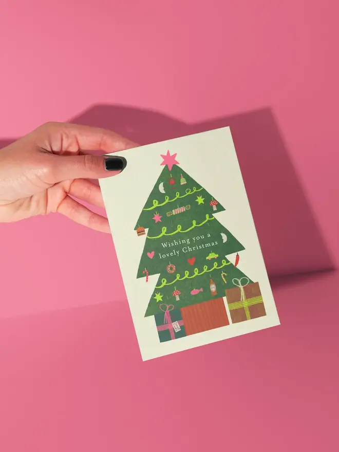 wishing you a lovely christmas illustrated card. illustrated christmas tree with gifts on a white card.