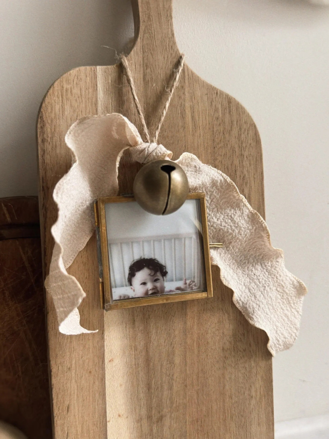 Personalised baby's first Christmas hanging frame. Letterpress printed with a photograph in a bronze frame.