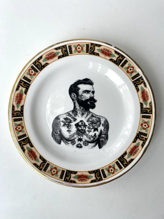 a vintage plate with ornate border, within the centre i have printed the vintage style image of a victorian tattooed sailor man