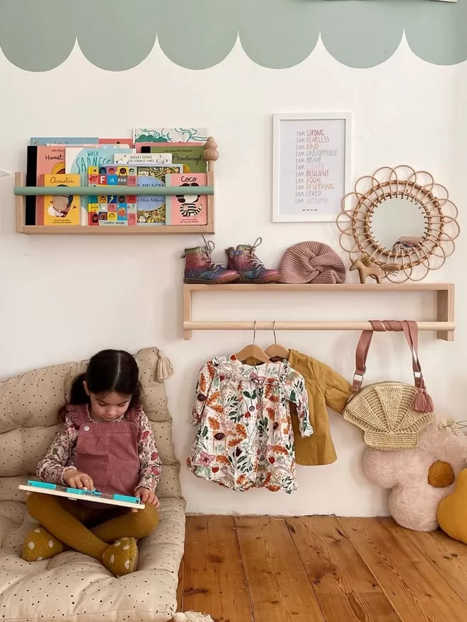 A sweet kids reading corner with a small and large shelf. One filled with books, one for clothes storage