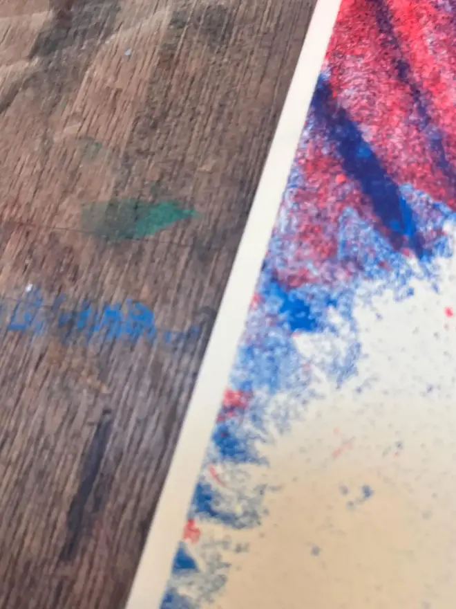 The Beatles Handmade Risograph Gig Poster, against a wooden table. 