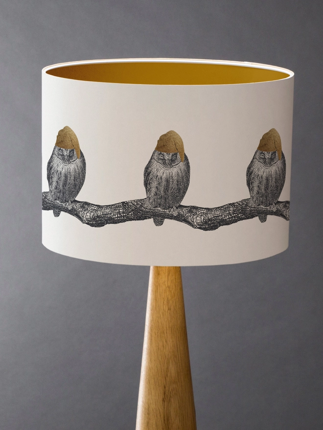 Drum Lampshade featuring little owls wearing a gold nightcap sitting on a branch on a wooden base 