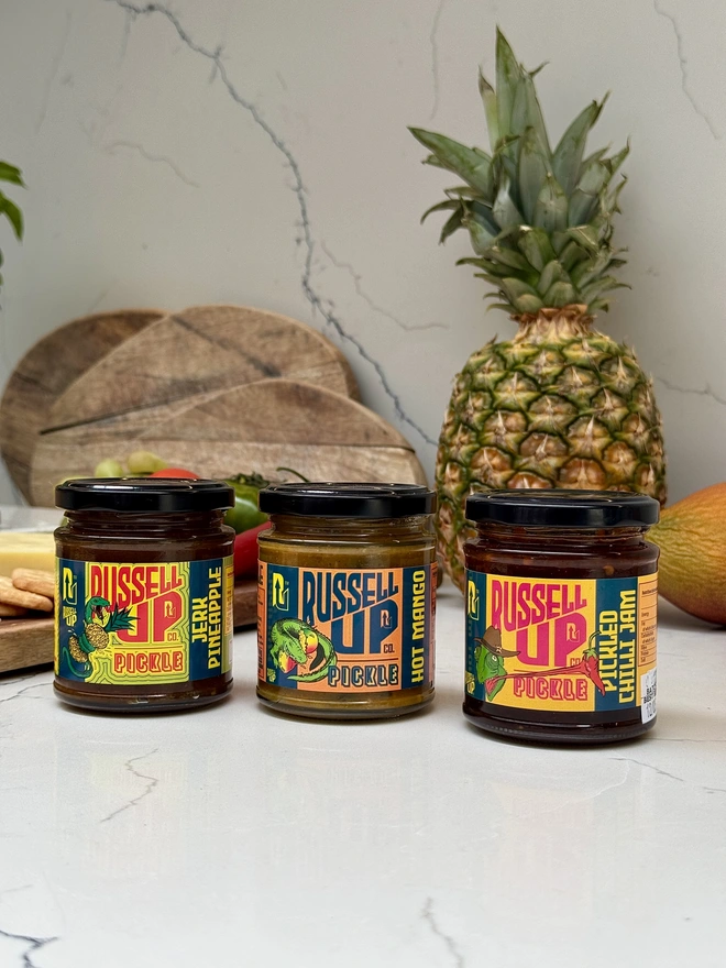 father's day pickles - spice set. a set of three jars of pickle photographed on a counter top.